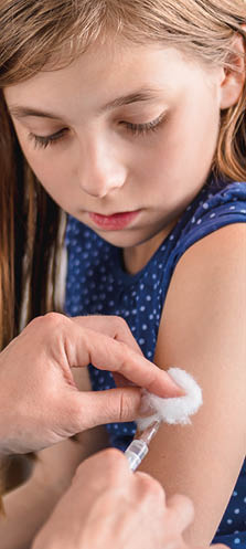 Pediatrics female doctor giving a young girl a vaccine shot in the arm