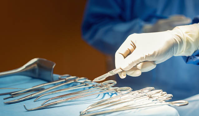 Detail shot of steralized surgery instruments with a hand grabbing a tool 