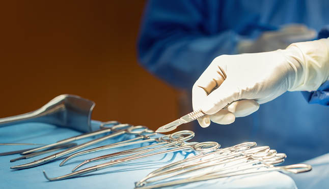 Detail shot of steralized surgery instruments with a hand grabbing a tool 