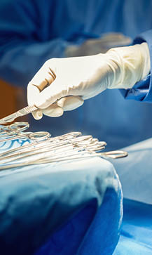 Detail shot of steralized surgery instruments with a hand grabbing a tool 
