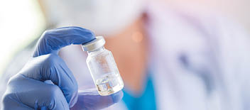 Female doctor with a stethoscope on shoulder holding syringe and vaccine  Healthcare And Medical concept 