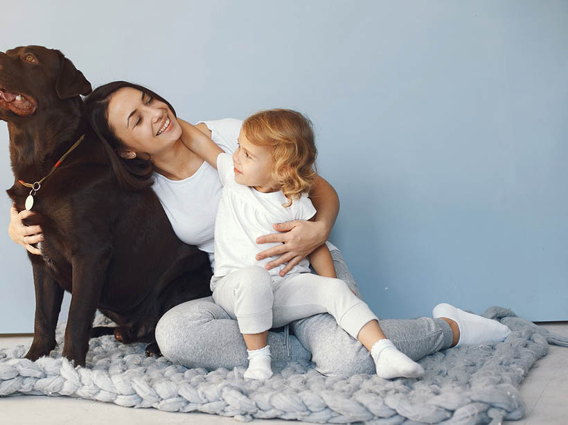 Beautiful woman with child  Woman in a white shirt  Family playing with big dog 